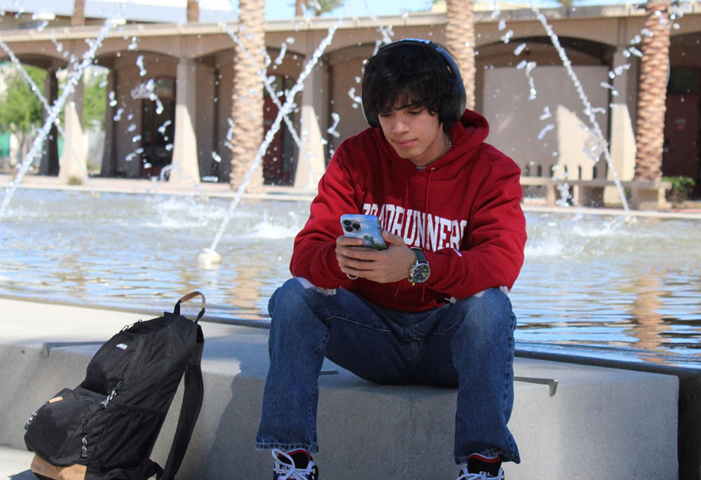 Student sitting near campus fountain